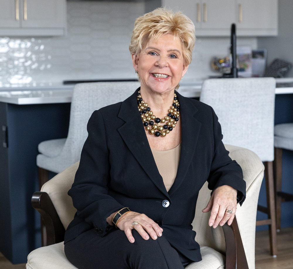Susan McKillop smiling outside a bright, cozy home